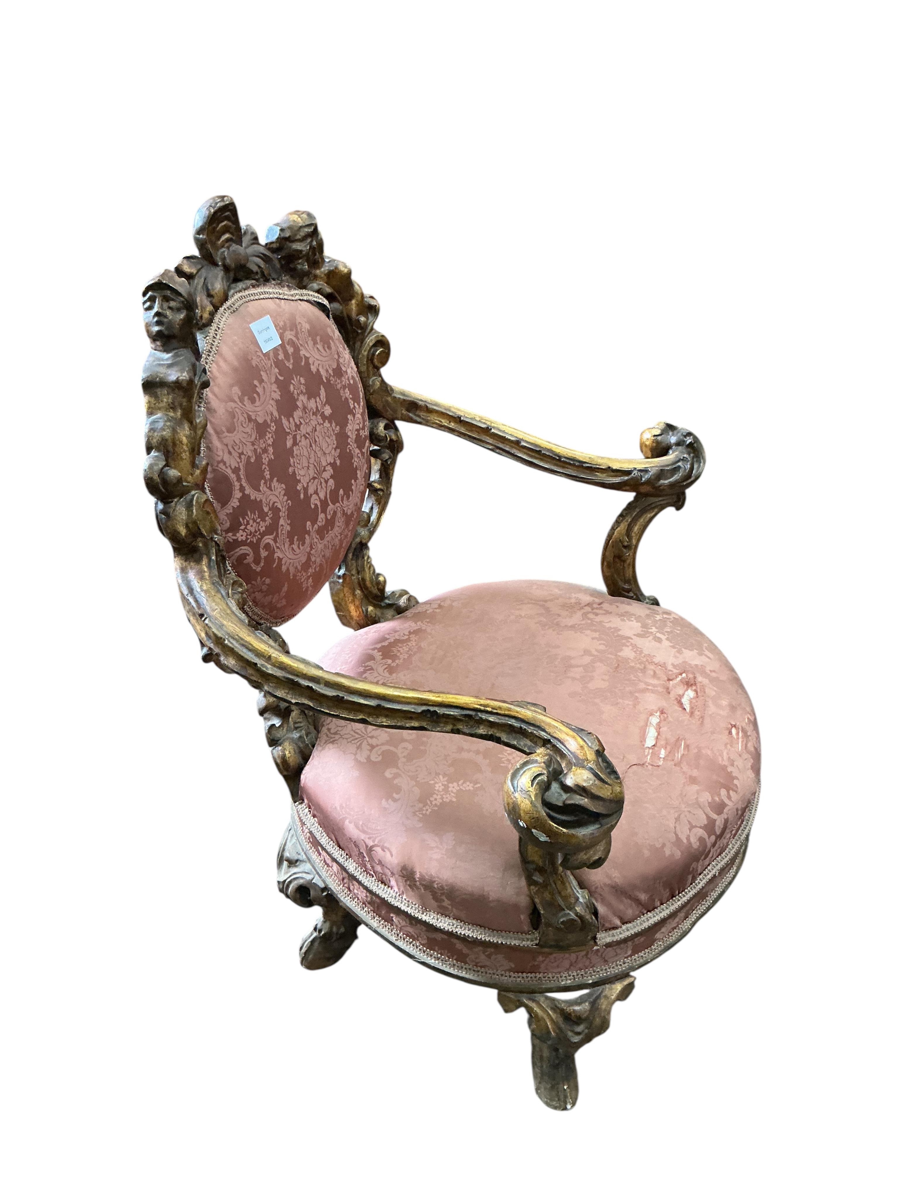 A 19th century Italian parcel gilt baroque revival armchair decorated with caryatids and leaf scrolls, upholstered in pink damask, fabric torn, width 80cm, depth 60cm, height 90cm